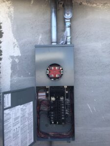 An open electrical panel and meter base on a building exterior by Neptune Electric LLC in Las Vegas, NV
