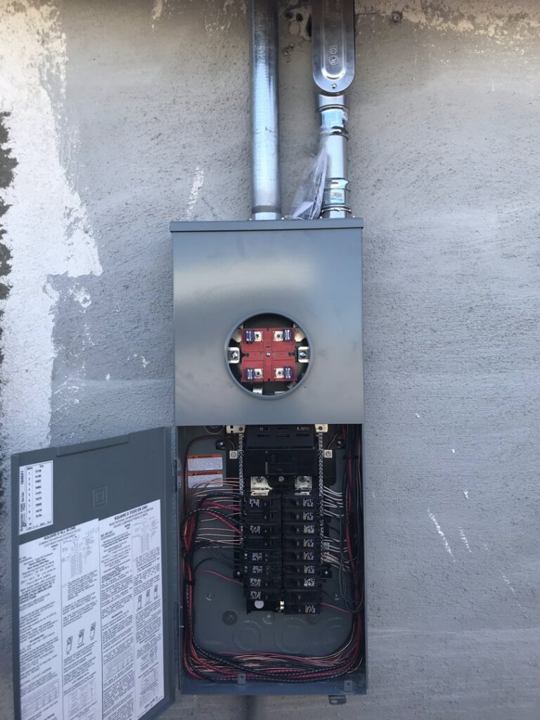 An open electrical panel and meter base on a building exterior by Neptune Electric LLC in Las Vegas, NV