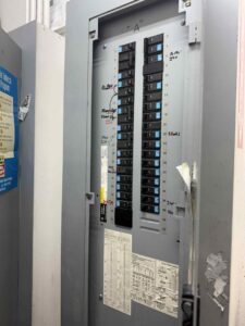 An open electrical panel with multiple circuit breakers, showing electrical work by ETF Electric LLC in Las Vegas, NV.