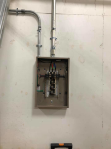 An electrical panel and conduit installation on a wall by Jon Chamberlain Electrical Services in Saxton, PA.