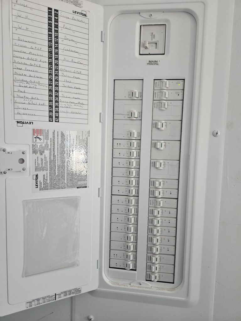 An open electrical panel with circuit breakers and wiring labels, showing electrical work by J3 Services in Goose Creek, SC.