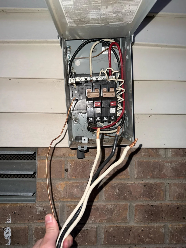 An electrician working on an open electrical panel and breaker box at a home in Los Angeles, CA by Ask Electricians.