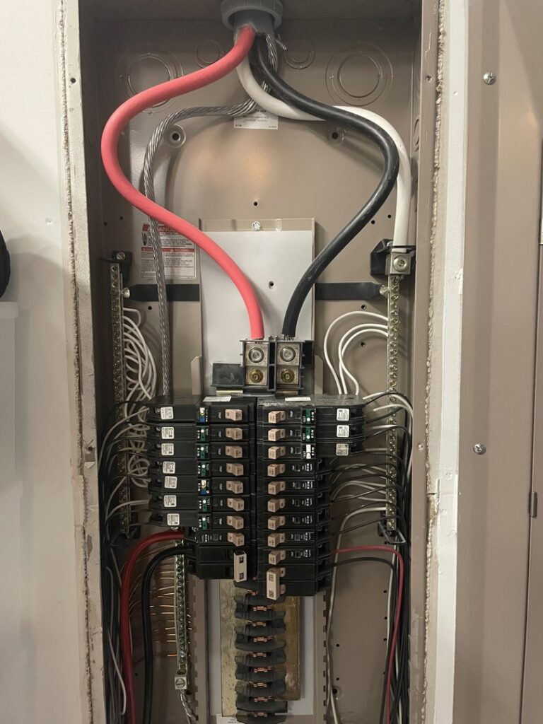 An open electrical panel (breaker box) with wiring by Clarity Handyman Service in Raleigh, NC