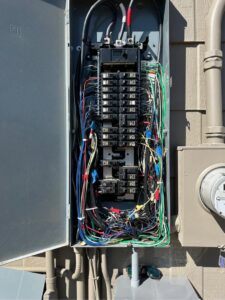 An open electrical panel, also known as a breaker box, showing complex wiring and circuit breakers by Legacy Electric in Westminster, CO.