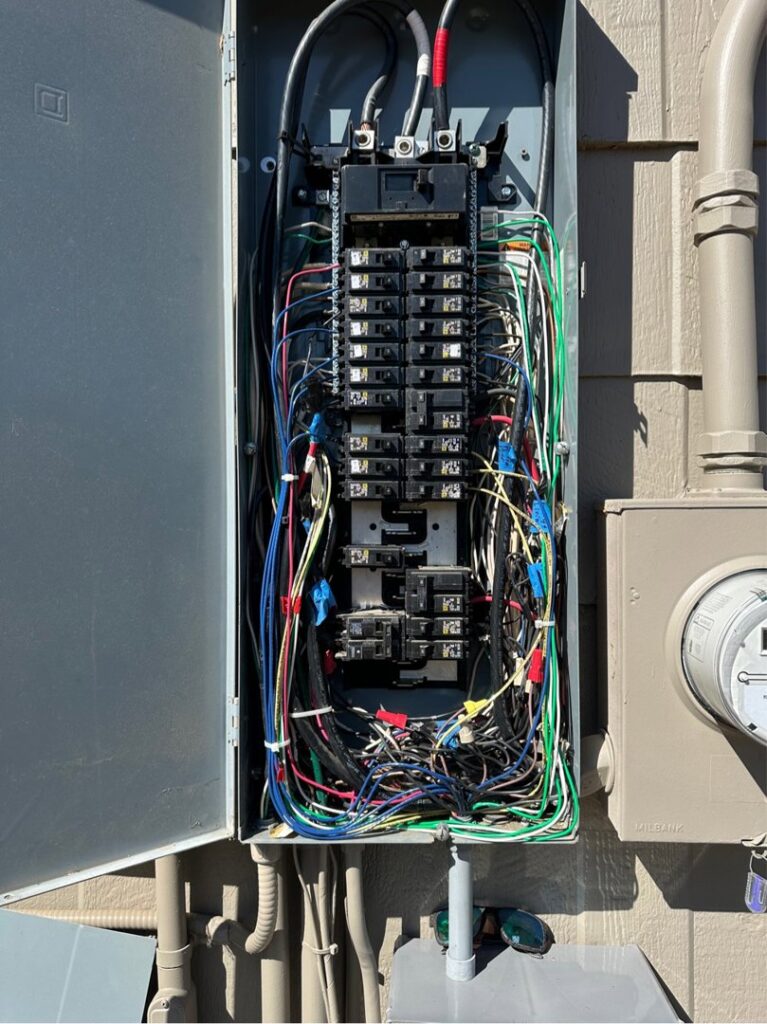 An open electrical panel, also known as a breaker box, showing complex wiring and circuit breakers by Legacy Electric in Westminster, CO.