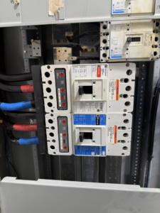 Electrical panel with circuit breakers and wiring, serviced by Power Tech Electrical Services in Durham, NC.