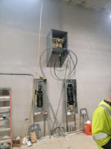 New electrical panels and conduits being installed on a wall by FOXX & Hounds Electric in Sioux City, IA.