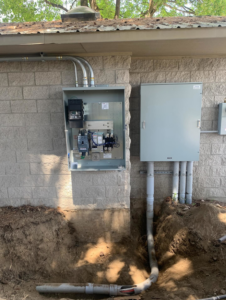 An open electrical panel and conduit installation on an exterior wall by Interstate Electrical Contractors in Dalton Gardens, ID.