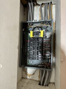 An electrical panel with multiple conduits and wiring installed in a wall by Sunrise Electric LLC in Kalispell, MT.