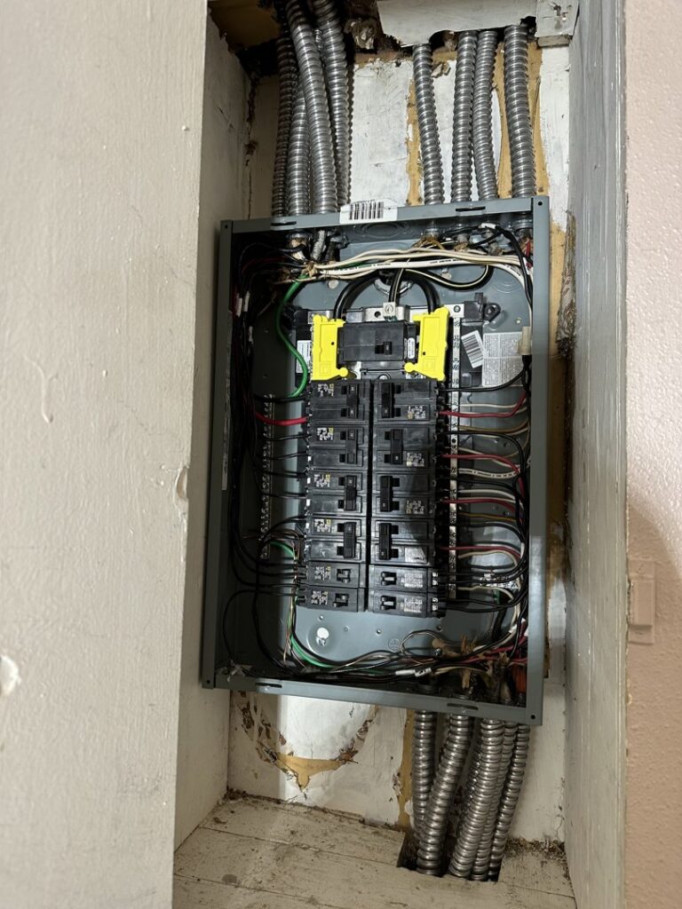 An electrical panel with multiple conduits and wiring installed in a wall by Sunrise Electric LLC in Kalispell, MT.
