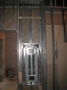 Electrical panel installation with conduits and wiring during construction by Nech Electric Services Inc. in Chicago, IL.