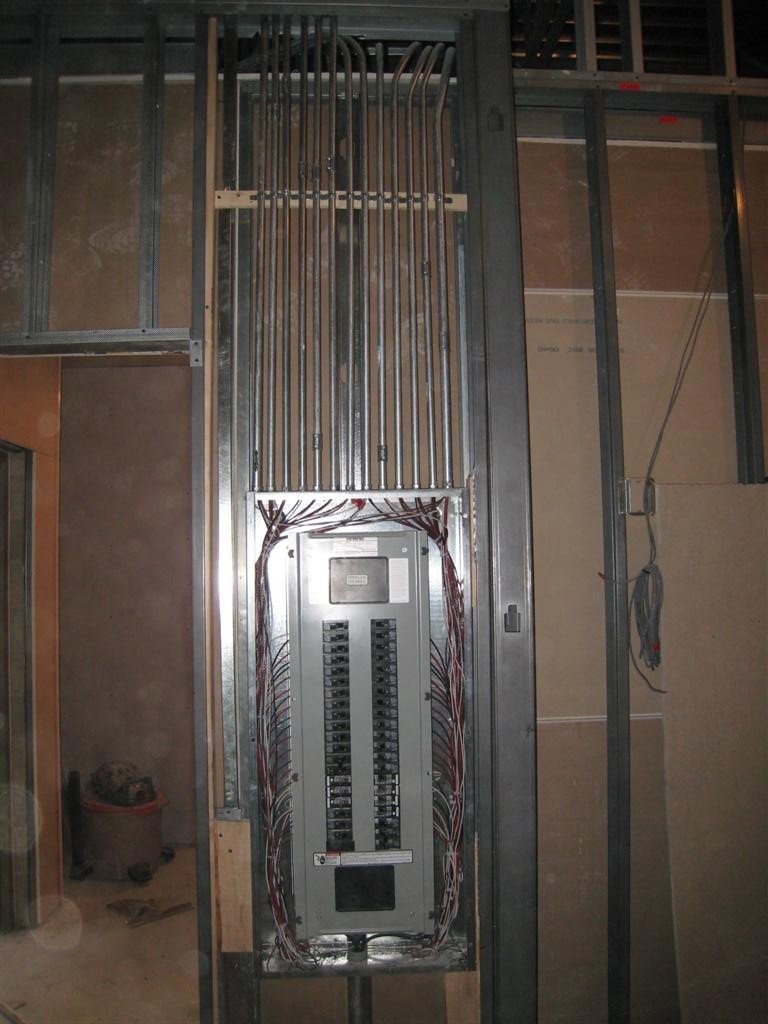 Electrical panel installation with conduits and wiring during construction by Nech Electric Services Inc. in Chicago, IL.
