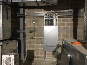 An electrical panel with multiple conduits installed on a brick wall by BrotherlyLove Electric LLC in Houston, TX.