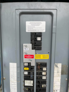 An open electrical panel showing a generator interlock kit and circuit breakers installed by Mcgehee Electric, LLC in Montgomery, AL.