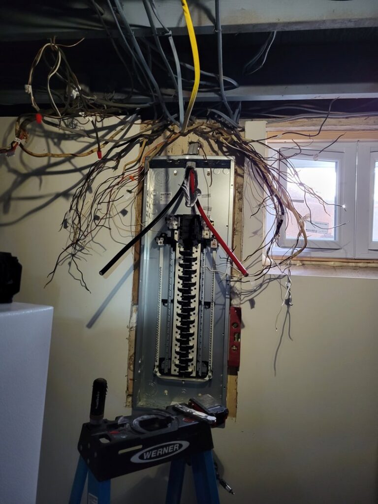 An open electrical panel during installation or repair, with numerous wires being connected by Maiolo Electric in Pittsburgh, PA.