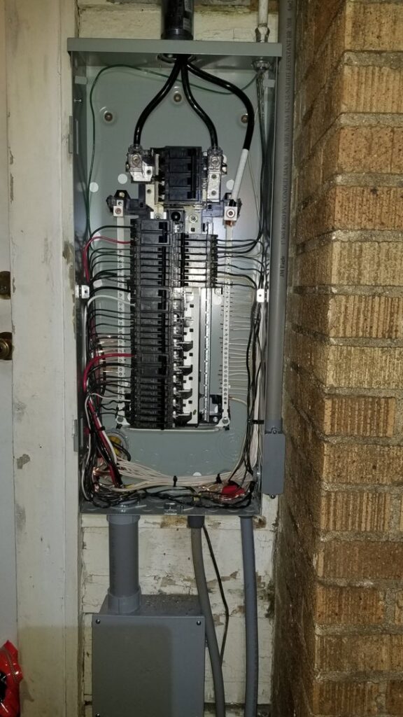 An open electrical panel with wiring and circuit breakers, showcasing an electrician's work by Anytime Electrical in Baton Rouge, LA.