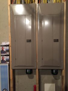 Two finished electrical panel installations on a framed wall by Electric Today in Indianapolis, IN.