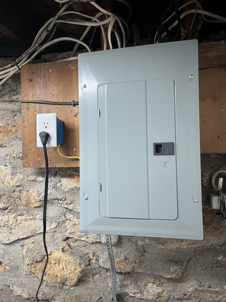A newly installed electrical panel and wiring on a stone wall by In the Light Electrical LLC in Kansas City, KS