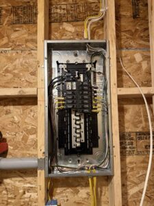 A newly installed electrical panel and wiring in a framed wall by Rudis Electrical LLC in Scranton, PA.