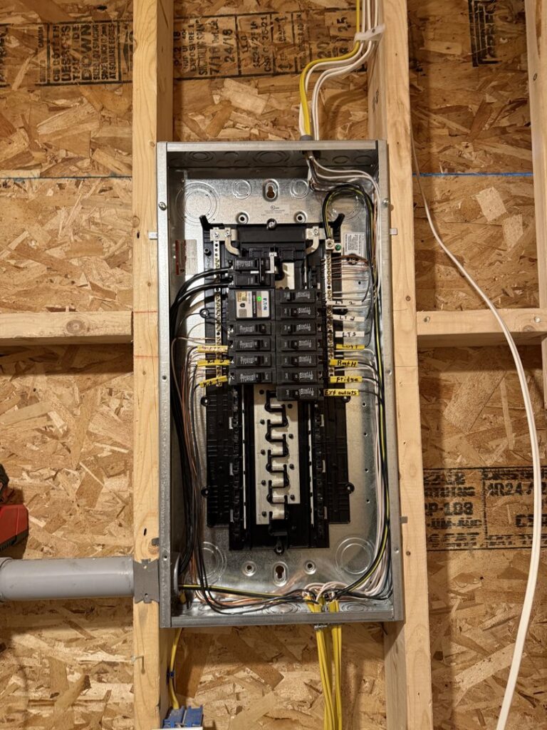 A newly installed electrical panel and wiring in a framed wall by Rudis Electrical LLC in Scranton, PA.