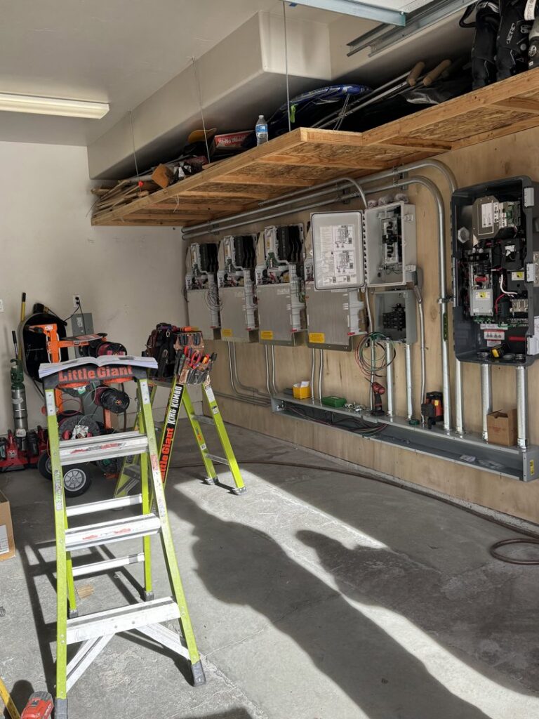 Multiple electrical panels and solar inverters installed on a wall by Pioneer Electric LLC in West Valley City, UT.