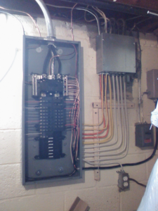 An electrical panel and wiring installed on a basement wall by U-R Wired in Baltimore, MD.