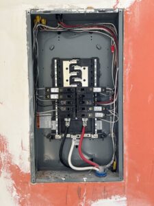An electrical panel installation with wiring and breakers on an unfinished wall by F&C Electrical Services LLC in Iowa City, IA.