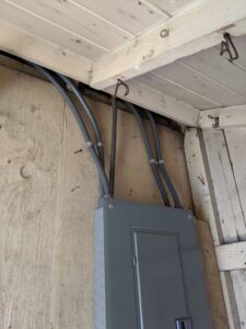 An electrical panel and conduit installation on a wooden wall by ZAP Electric LLC in Greeley, CO.