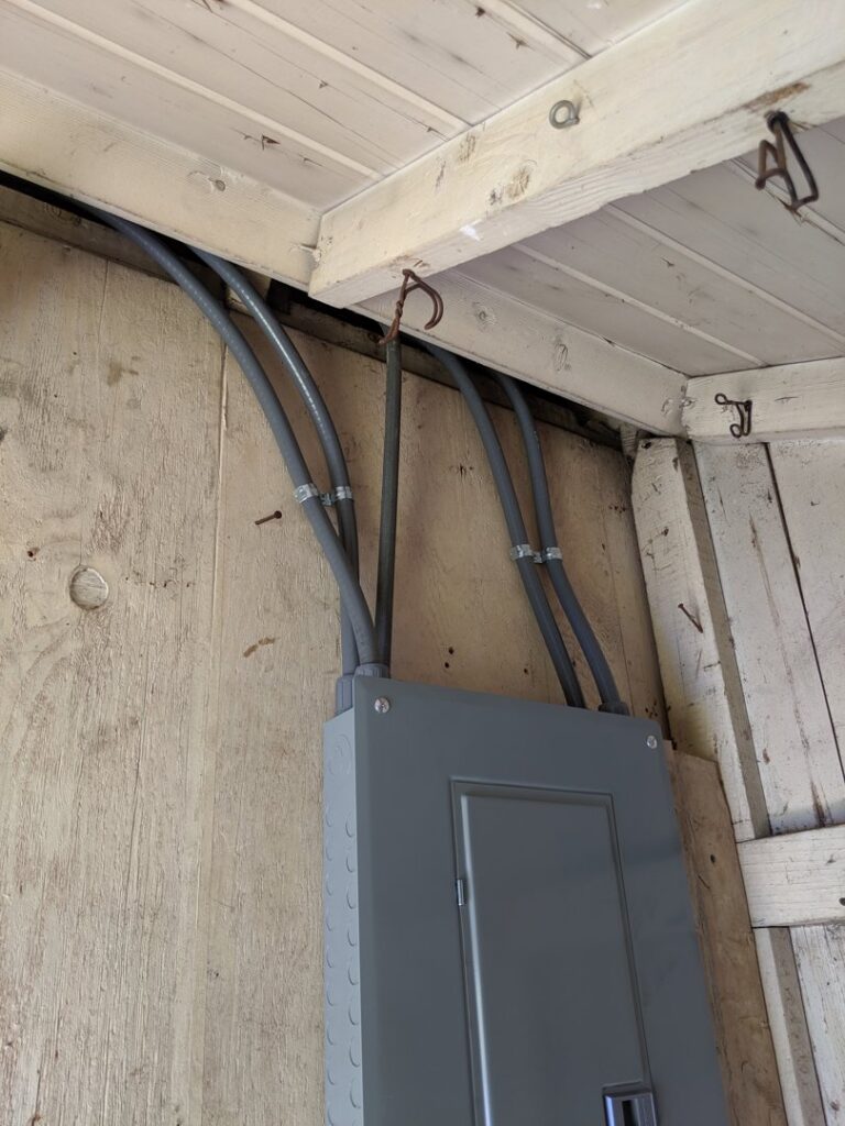 An electrical panel and conduit installation on a wooden wall by ZAP Electric LLC in Greeley, CO.