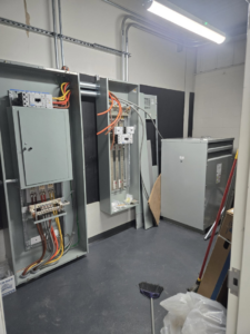 An electrical panel installation with exposed wiring and conduits by ZJW Electric LLC in West Hartford, CT