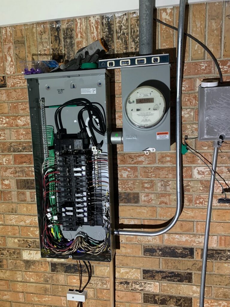 An open electrical panel and meter base on a brick wall, installed by AVA Electric, LLC in Fort Worth, TX.