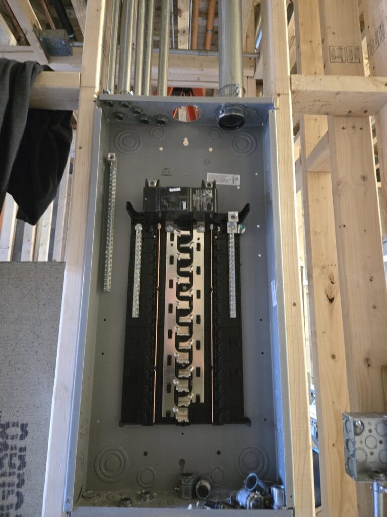 An electrical panel box and conduit installed during rough-in construction by ILIC Electric in Chicago, IL.