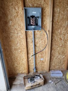 An electrical panel during rough-in installation on a plywood wall by Minards Electric LLC in Dickinson, ND.