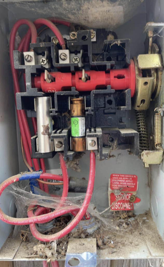 An open electrical panel with fuses and wiring, showing a service disconnect, serviced by C&J Electric in Miles City, MT.