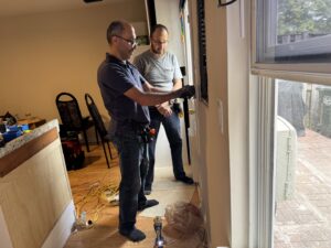 Electricians from Square Electrical LLC in Alexandria, VA, performing an electrical panel service or upgrade in a home.