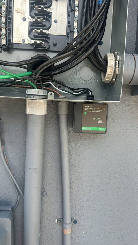 An open electrical panel with wiring and a surge protection device installed by PlugTech LLC in Orlando, FL