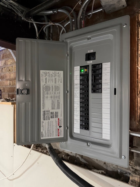A newly installed or upgraded electrical panel with its cover open, showing the circuit breakers and wiring, by Arnold Electrical Repair & Installation in Chicago, IL.