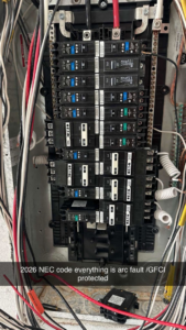 An open electrical panel showing circuit breakers and wiring, indicating an upgrade by JL's Electric Inc. in Norman, OK.