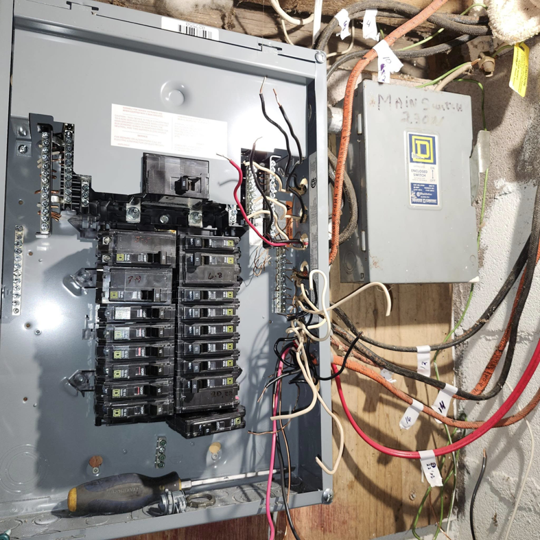 An electrical panel showing circuit breakers and an older main switch, indicating an upgrade or repair by SEL Electric in Truro, NS.