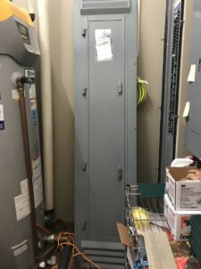 An electrical panel and water heater in a utility room, serviced by Bill's Electric Inc. in Springfield, MO.