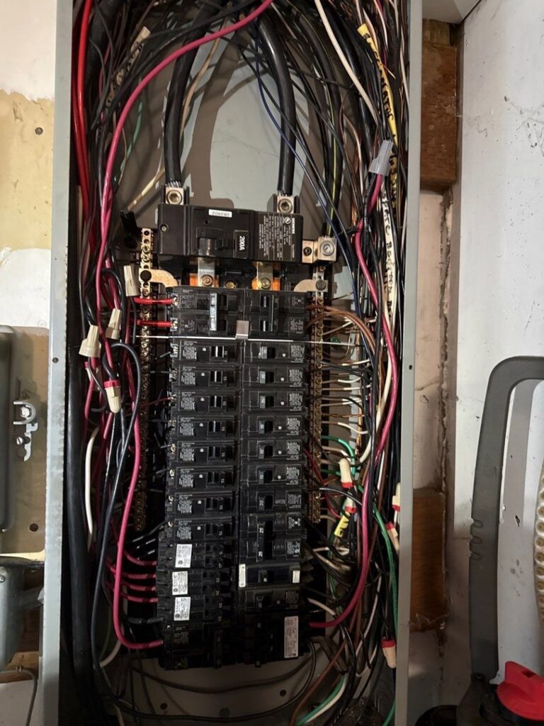 An open electrical panel showing complex wiring and circuit breakers, indicating electrical service by Beaver Electric in Hillsboro, OR.
