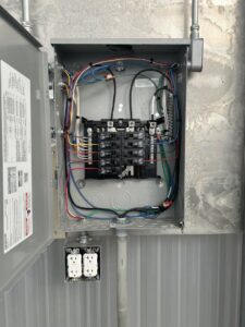 Neatly wired electrical panel with circuit breakers and an outlet installed by Justin Benevage Electrical, LLC in Lake Charles, LA