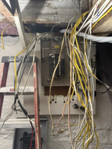 An open electrical panel with numerous wires being worked on by Joshua Melendez Electrician LLC in New Bedford, MA.