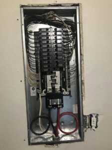 An interior view of an electrical panel with wiring and circuit breakers, installed by 60HZ Electric in St. Petersburg, FL.