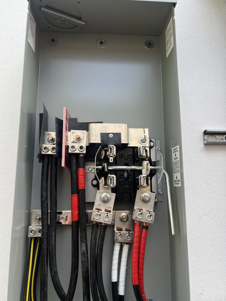 Close-up view of an electrical panel with wiring connections, installed by Llanos Electric Builders in Houston, TX.