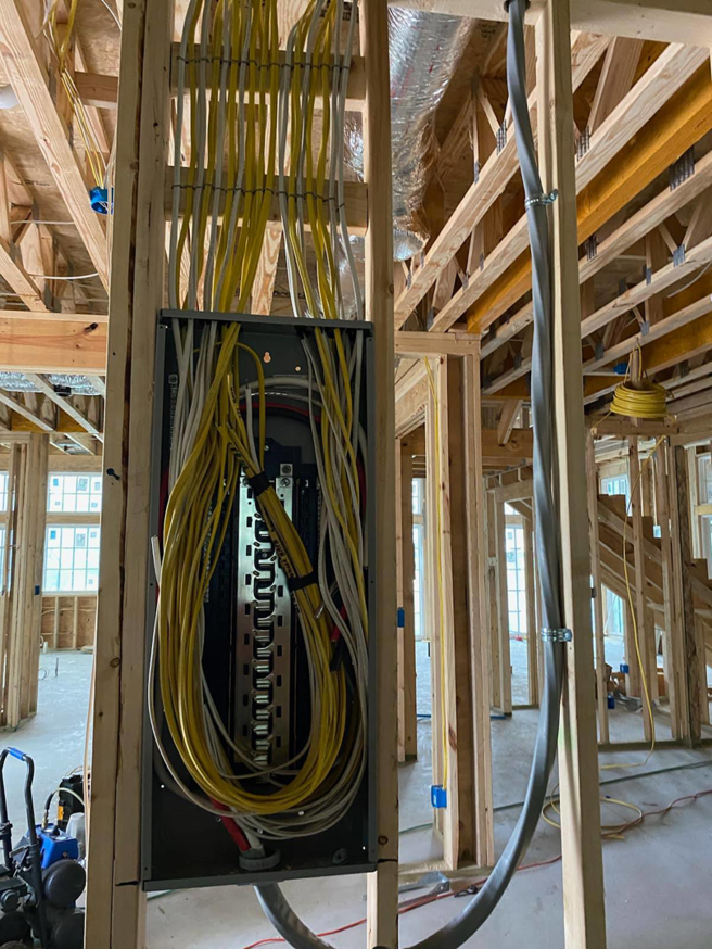 An electrical panel with yellow and white wiring installed during new construction by King Electrical Services, LLC in Hoover, AL.