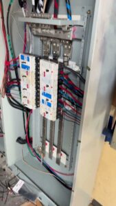 Detailed view of an open electrical panel with complex wiring and circuit breakers by Prime Electric in Bellevue, WA.