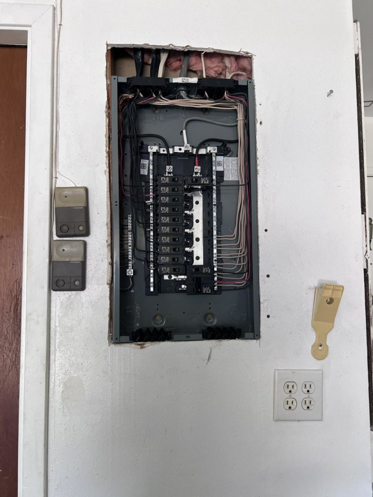 An open electrical panel showing wiring and circuit breakers, serviced by Quistian Lighting in Arlington, TX