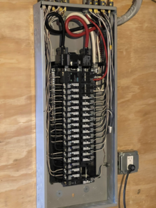 An open electrical panel showing organized wiring and circuit breakers by Richard A. Gibbons in Dracut, MA.