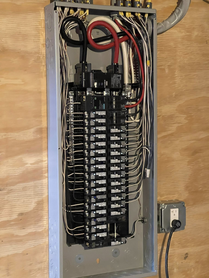 An open electrical panel showing organized wiring and circuit breakers by Richard A. Gibbons in Dracut, MA.